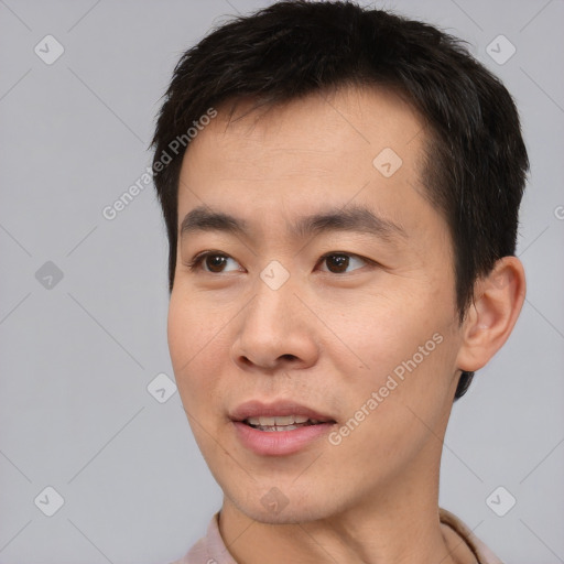 Joyful asian young-adult male with short  brown hair and brown eyes