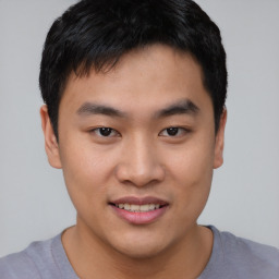 Joyful asian young-adult male with short  brown hair and brown eyes