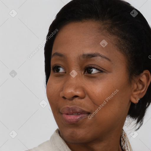 Joyful black young-adult female with short  black hair and brown eyes