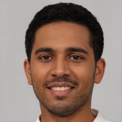 Joyful latino young-adult male with short  black hair and brown eyes