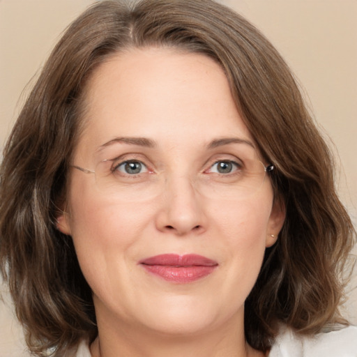 Joyful white adult female with medium  brown hair and green eyes