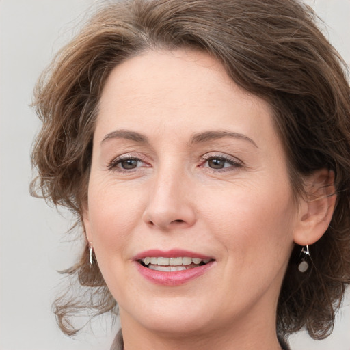 Joyful white adult female with medium  brown hair and grey eyes