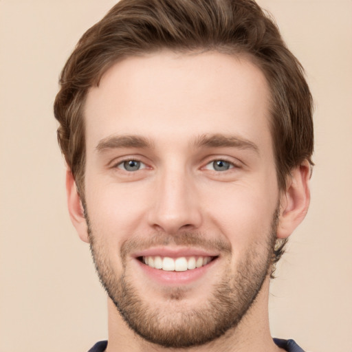 Joyful white young-adult male with short  brown hair and grey eyes