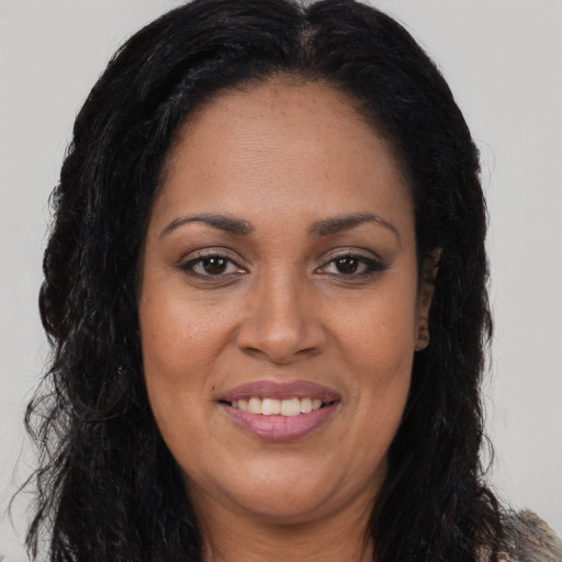 Joyful black adult female with long  brown hair and brown eyes