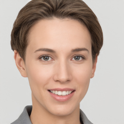 Joyful white young-adult female with short  brown hair and grey eyes