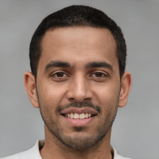 Joyful white young-adult male with short  black hair and brown eyes