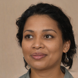 Joyful black adult female with medium  brown hair and brown eyes