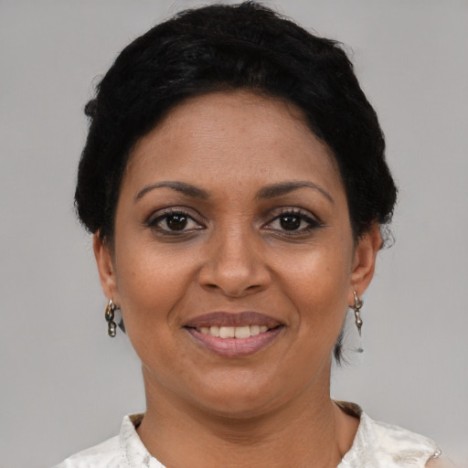 Joyful latino adult female with short  black hair and brown eyes