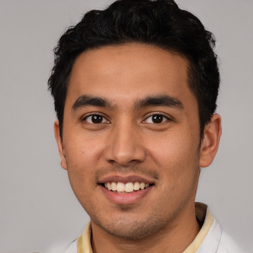 Joyful latino young-adult male with short  black hair and brown eyes