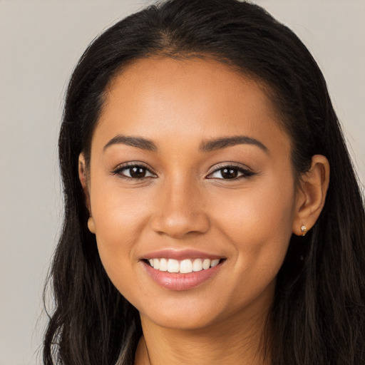 Joyful latino young-adult female with long  brown hair and brown eyes