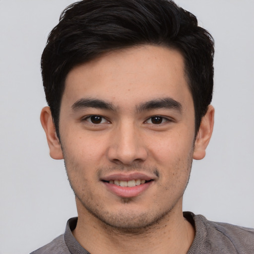 Joyful asian young-adult male with short  black hair and brown eyes