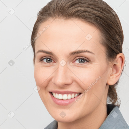 Joyful white young-adult female with medium  brown hair and grey eyes