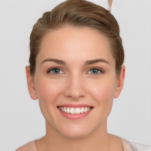 Joyful white young-adult female with short  brown hair and grey eyes