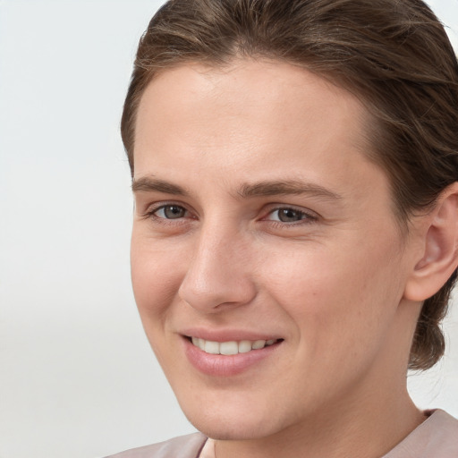 Joyful white young-adult female with short  brown hair and grey eyes