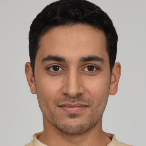 Joyful latino young-adult male with short  black hair and brown eyes