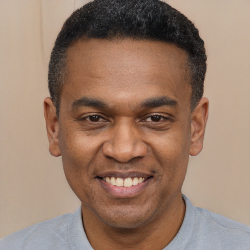 Joyful latino adult male with short  black hair and brown eyes