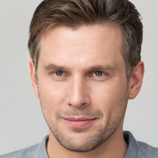 Joyful white adult male with short  brown hair and grey eyes