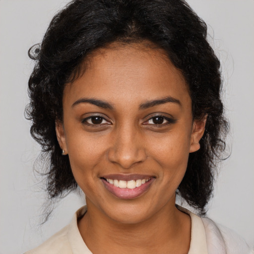 Joyful black young-adult female with medium  brown hair and brown eyes