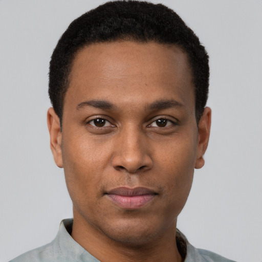 Joyful black young-adult male with short  brown hair and brown eyes