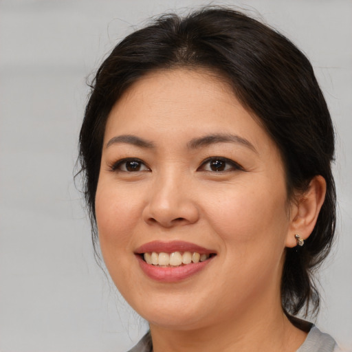 Joyful asian young-adult female with medium  brown hair and brown eyes