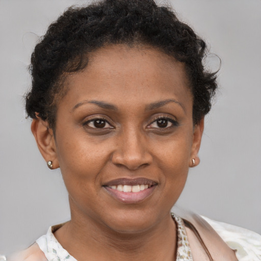 Joyful black young-adult female with short  brown hair and brown eyes