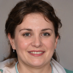 Joyful white adult female with medium  brown hair and blue eyes