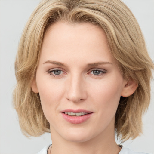 Joyful white young-adult female with medium  brown hair and blue eyes