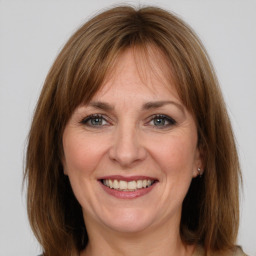 Joyful white adult female with medium  brown hair and grey eyes