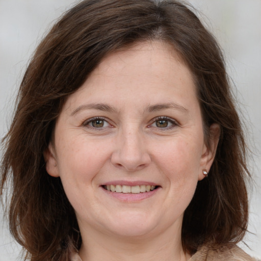 Joyful white adult female with long  brown hair and brown eyes