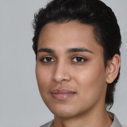 Joyful latino young-adult female with short  black hair and brown eyes