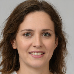 Joyful white young-adult female with medium  brown hair and green eyes