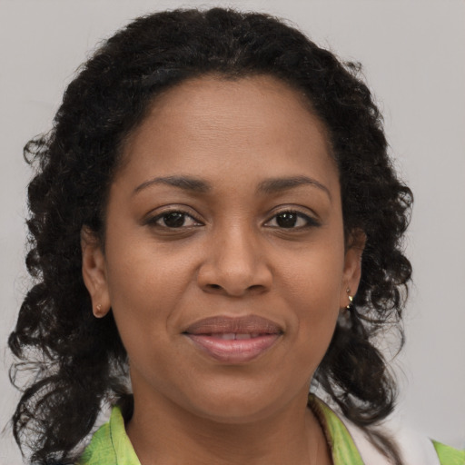 Joyful black young-adult female with medium  brown hair and brown eyes