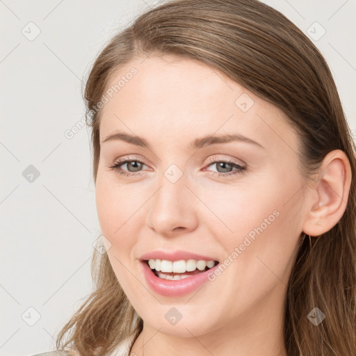 Joyful white young-adult female with long  brown hair and grey eyes