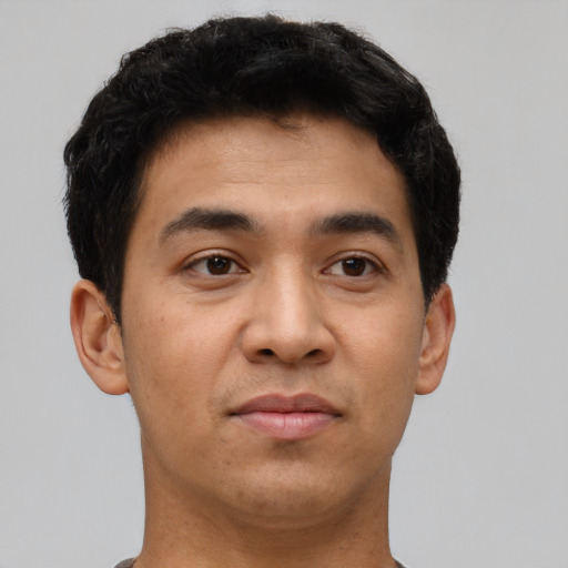 Joyful latino young-adult male with short  brown hair and brown eyes