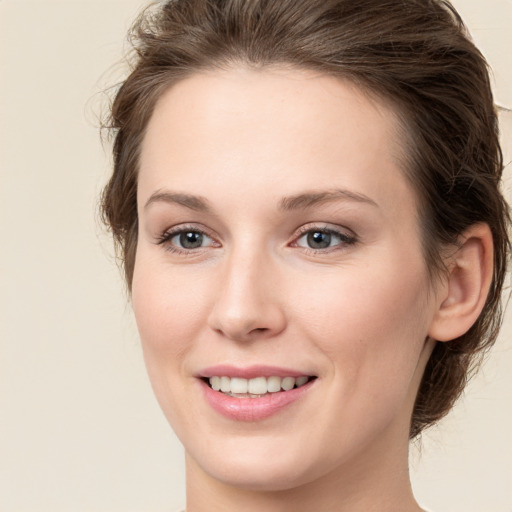 Joyful white young-adult female with medium  brown hair and green eyes