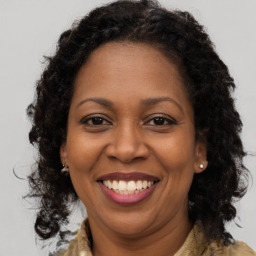 Joyful black adult female with long  brown hair and brown eyes