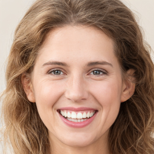 Joyful white young-adult female with long  brown hair and green eyes