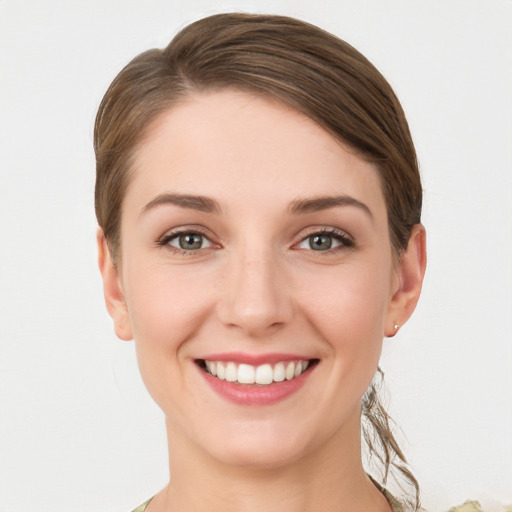 Joyful white young-adult female with medium  brown hair and grey eyes