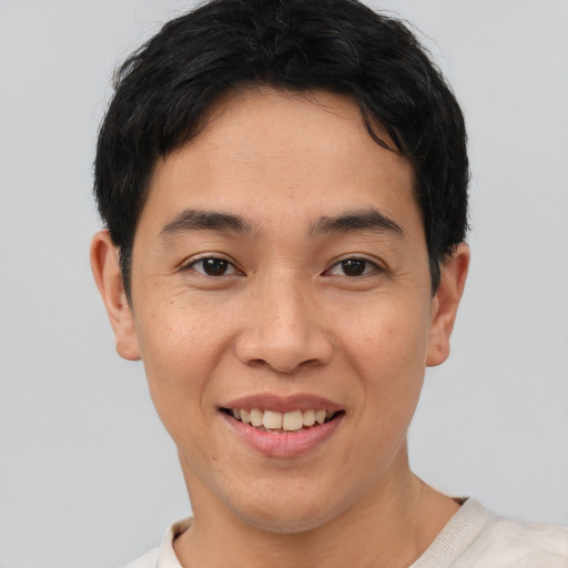 Joyful asian young-adult male with short  brown hair and brown eyes