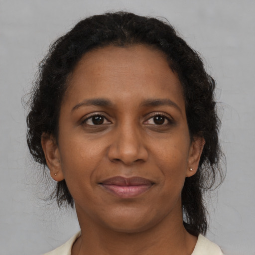 Joyful black adult female with medium  brown hair and brown eyes