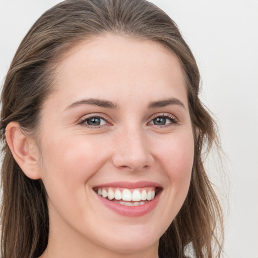 Joyful white young-adult female with long  brown hair and grey eyes