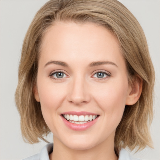 Joyful white young-adult female with medium  brown hair and blue eyes