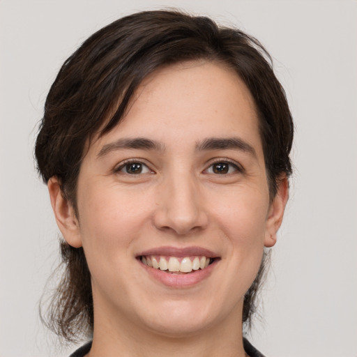 Joyful white young-adult female with medium  brown hair and brown eyes