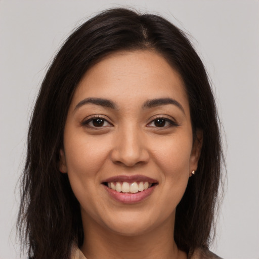 Joyful latino young-adult female with long  brown hair and brown eyes