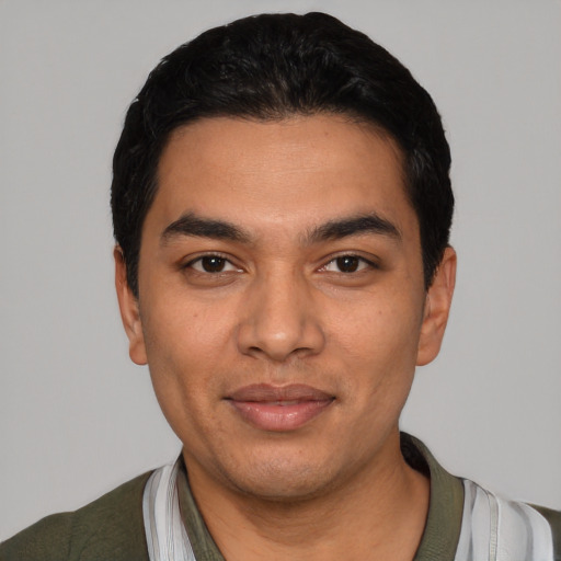 Joyful latino young-adult male with short  black hair and brown eyes