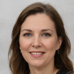 Joyful white adult female with medium  brown hair and grey eyes