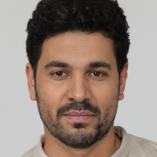 Joyful latino young-adult male with short  black hair and brown eyes
