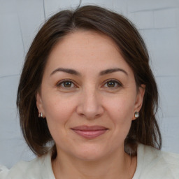 Joyful white adult female with medium  brown hair and brown eyes