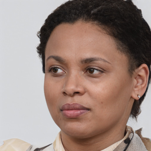 Joyful black young-adult female with short  brown hair and brown eyes