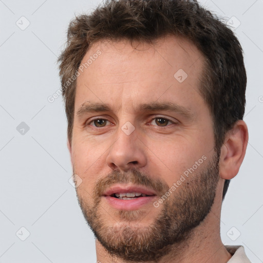 Joyful white adult male with short  brown hair and brown eyes